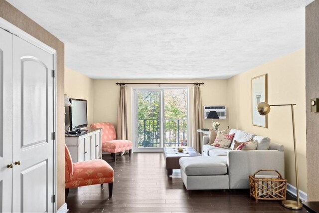 living room featuring a textured ceiling, dark wood finished floors, and baseboards