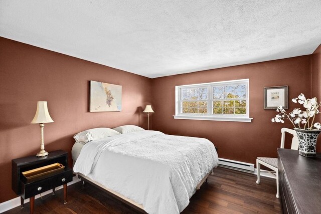 bedroom featuring dark wood-style flooring, baseboards, a baseboard radiator, and a textured ceiling