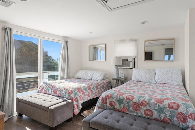bedroom featuring cooling unit, attic access, wood finished floors, and visible vents