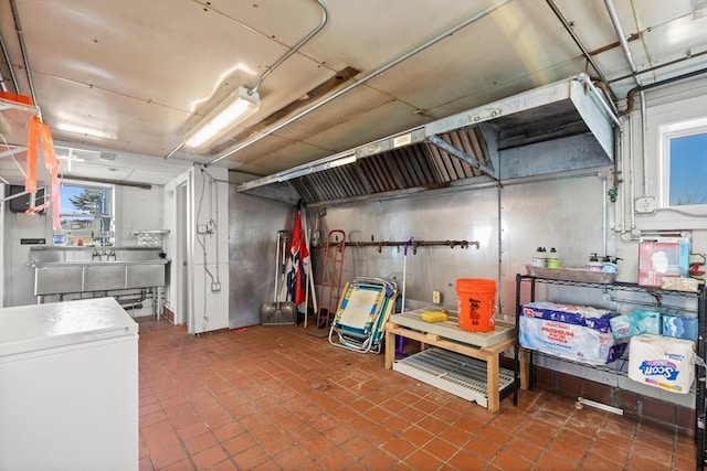 below grade area featuring a sink, tile patterned floors, and refrigerator
