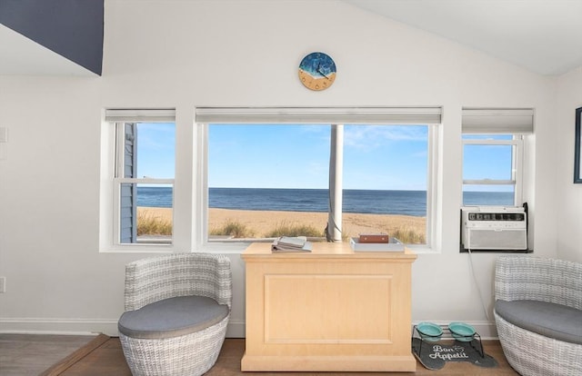 living area featuring cooling unit, baseboards, wood finished floors, a water view, and vaulted ceiling