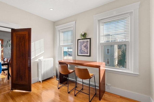 home office with radiator and light hardwood / wood-style flooring