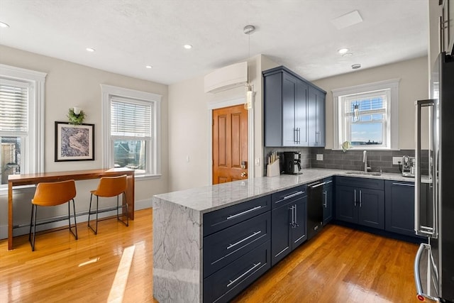 kitchen with tasteful backsplash, kitchen peninsula, sink, and light wood-type flooring