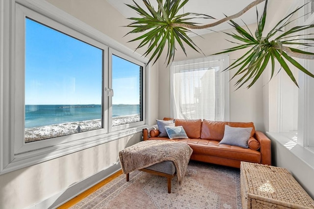 sunroom featuring a water view and a view of the beach