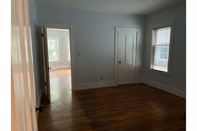 empty room with dark hardwood / wood-style flooring