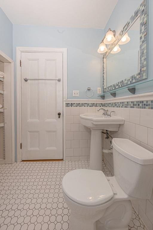 bathroom with tile walls and toilet