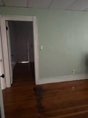 interior space with dark hardwood / wood-style floors and a drop ceiling