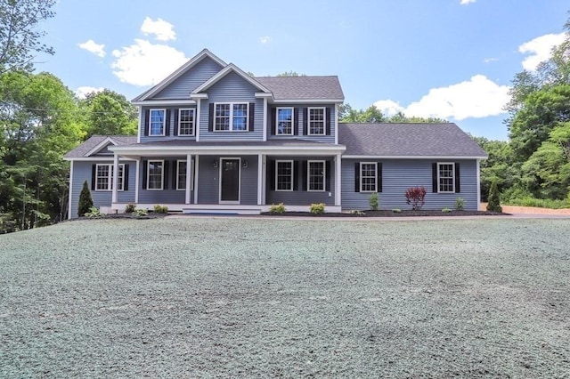 colonial house with covered porch and a shingled roof