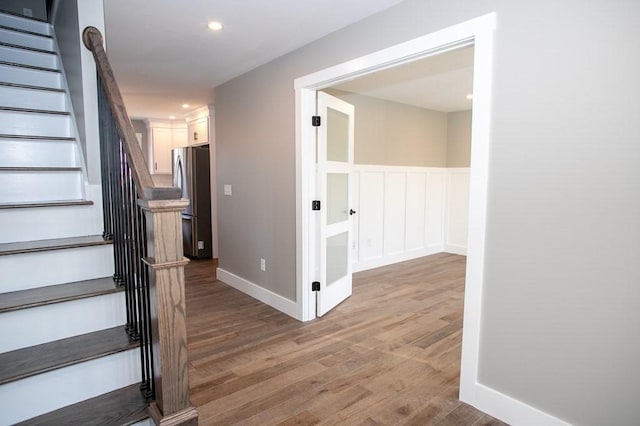 stairway with wood finished floors and recessed lighting
