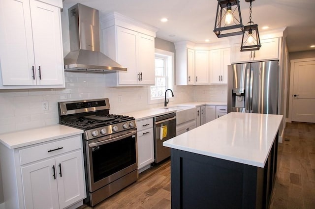 kitchen featuring wall chimney range hood, stainless steel appliances, a sink, dark wood-style flooring, and white cabinetry