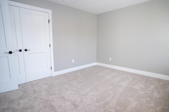 unfurnished bedroom with carpet floors, a closet, and baseboards