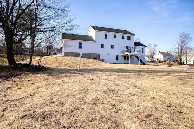 rear view of property with a wooden deck and stairs