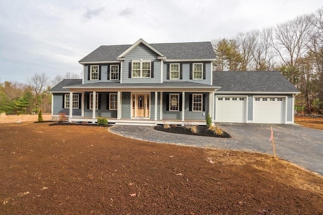 view of front facade featuring an attached garage, asphalt driveway, covered porch, and a shingled roof