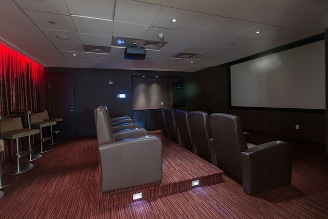 home theater with a drop ceiling and dark colored carpet