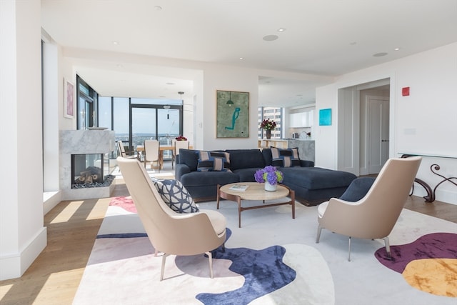 living room featuring a high end fireplace and light hardwood / wood-style floors