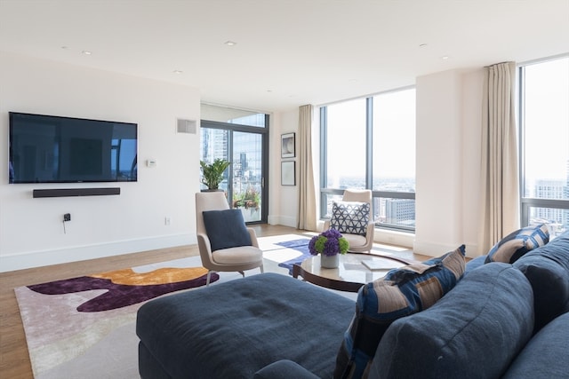 living room featuring floor to ceiling windows and light hardwood / wood-style floors