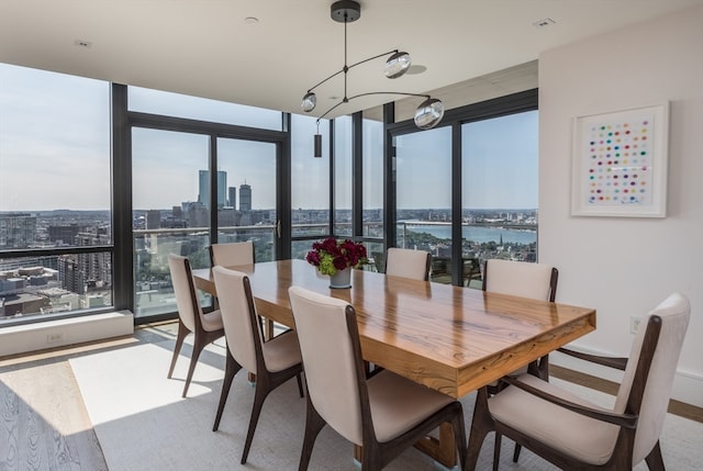 dining space with a water view, a chandelier, and expansive windows