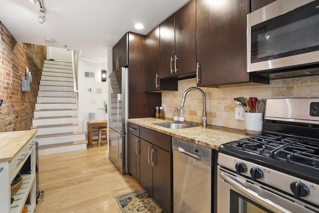 750 E 4th Unit 1, Boston, MA 02127 - kitchen with stainless steel appliances, a sink, light wood-type flooring, dark brown cabinetry, and tasteful backsplash