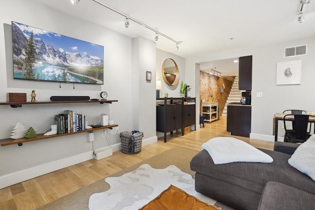 750 E 4th Unit 1, Boston, MA 02127 - living room featuring rail lighting, light wood finished floors, stairway, and baseboards