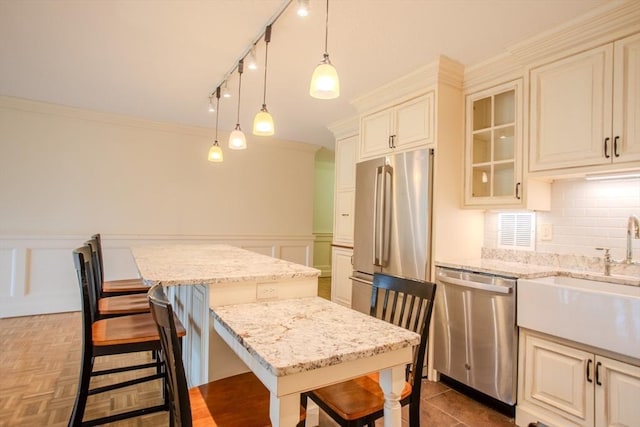111 Perkins St Unit 42, Boston, MA 02130 - kitchen featuring stainless steel appliances, a kitchen bar, a kitchen island, a sink, and backsplash