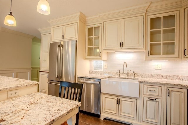 111 Perkins St Unit 42, Boston, MA 02130 - kitchen with stainless steel appliances, a sink, cream cabinets, pendant lighting, and ornamental molding