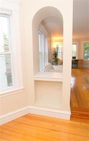 8 Fainwood Cir Unit 2, Cambridge, MA 02139 - hallway featuring wood finished floors, arched walkways, and baseboards
