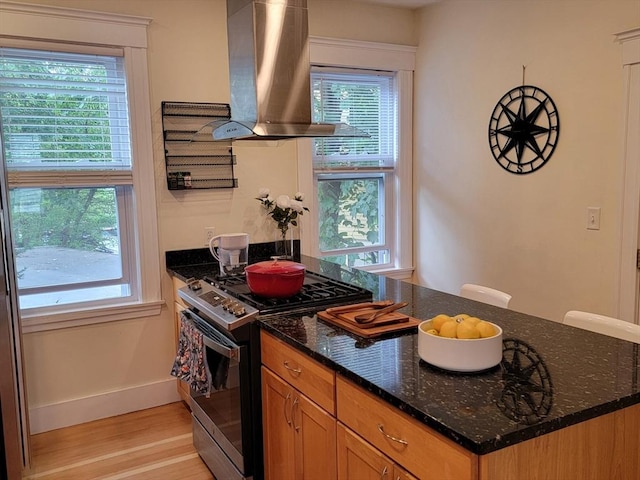 8 Fainwood Cir Unit 2, Cambridge, MA 02139 - kitchen featuring gas stove, wall chimney range hood, light wood-type flooring, and dark stone countertops