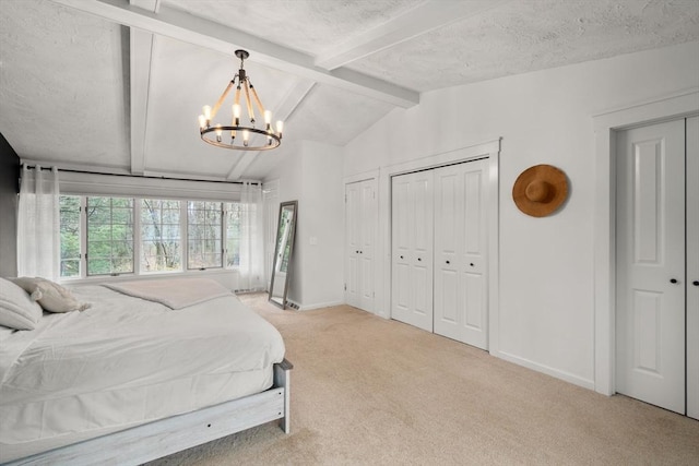 bedroom featuring vaulted ceiling with beams, baseboards, a chandelier, light colored carpet, and multiple closets