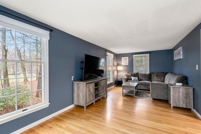 living area featuring light wood finished floors and baseboards