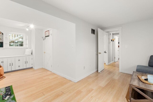 living room featuring baseboards, visible vents, and light wood-style floors