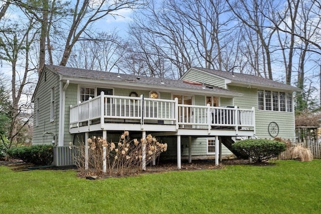 rear view of property featuring a wooden deck, a yard, and central air condition unit