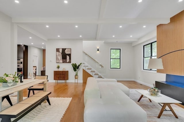 living area featuring light wood-type flooring, stairway, baseboards, recessed lighting, and beam ceiling