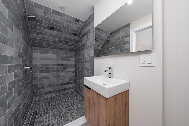 bathroom featuring tiled shower, vanity, and recessed lighting