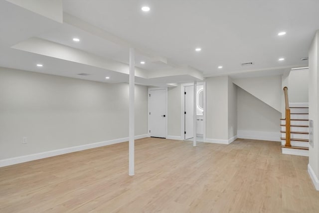 finished below grade area featuring recessed lighting, baseboards, light wood-style flooring, and stairs