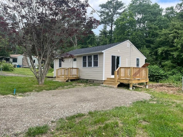 view of front of house with a front yard and a wooden deck