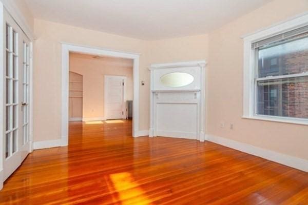 empty room with baseboards and wood finished floors