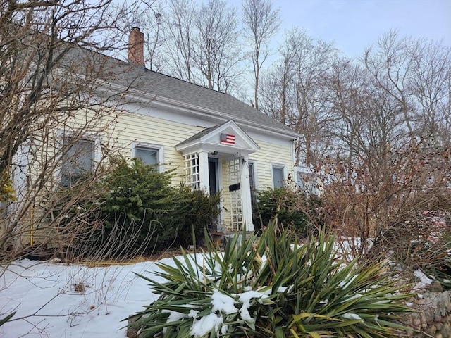 view of front of property featuring roof with shingles and a chimney