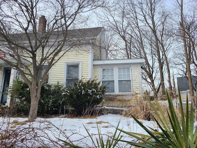 snow covered property with a chimney