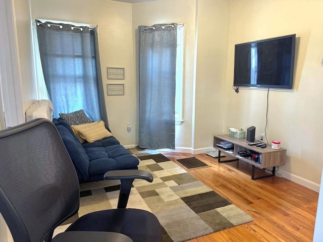 living area featuring light wood-style floors, visible vents, and baseboards
