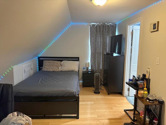 bedroom featuring vaulted ceiling and hardwood / wood-style flooring