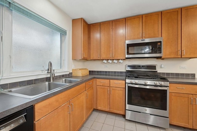 kitchen with light tile patterned floors, sink, and appliances with stainless steel finishes