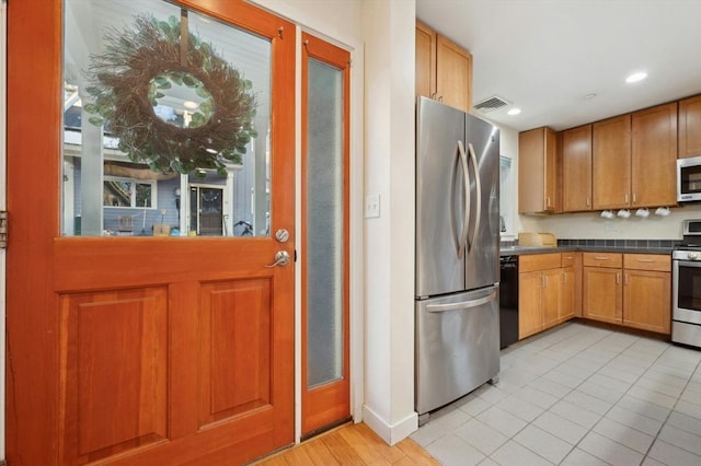 kitchen with appliances with stainless steel finishes and light tile patterned flooring