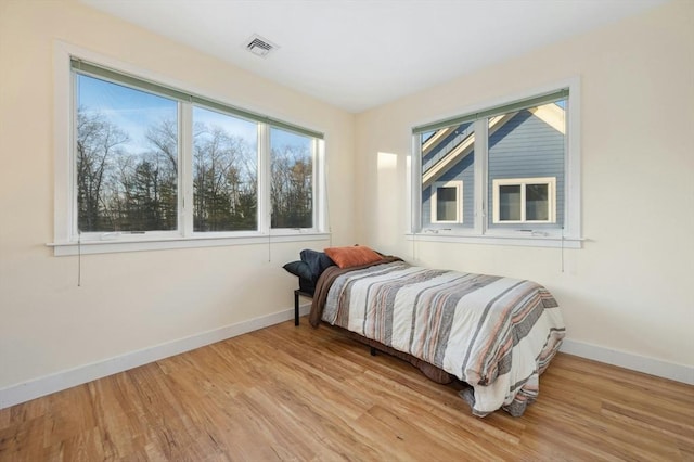 bedroom featuring light hardwood / wood-style flooring and multiple windows