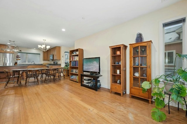 dining room featuring sink, a chandelier, and light hardwood / wood-style floors