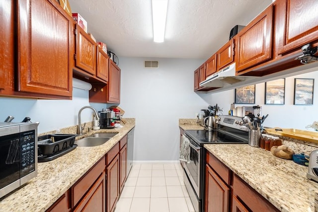 kitchen with light tile patterned flooring, stainless steel appliances, light stone countertops, and sink