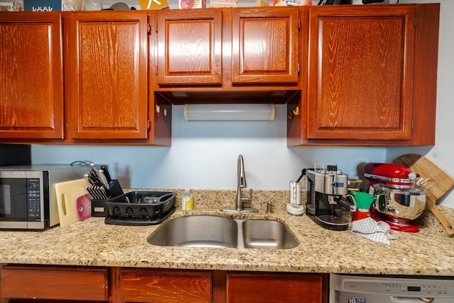 kitchen featuring light stone countertops, sink, and stainless steel appliances