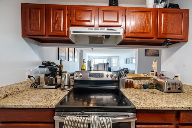 kitchen featuring stainless steel electric range oven and light stone countertops