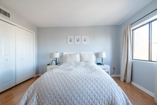 bedroom with light wood-type flooring and a closet