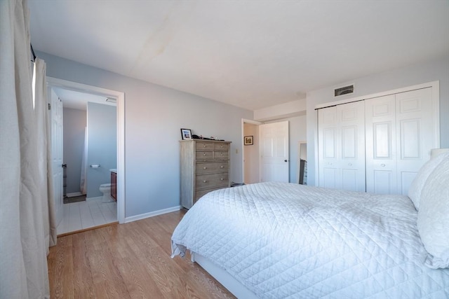 bedroom with a closet, ensuite bathroom, and light hardwood / wood-style flooring