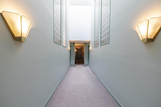 hallway featuring a towering ceiling